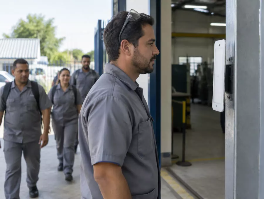 Operário diante do tablet na entrada da fábrica