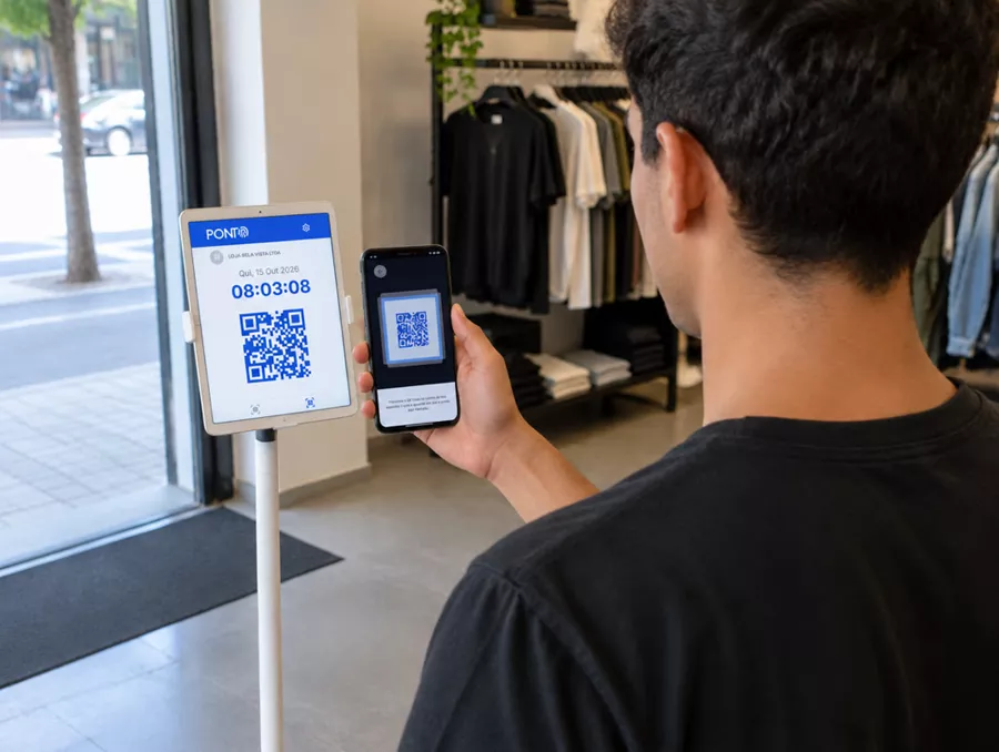Vendedor apontando o celular para o tablet na entrada da loja
