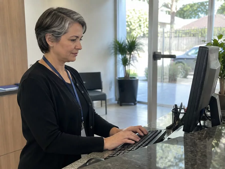 Funcionária marcando o ponto no computador da recepção